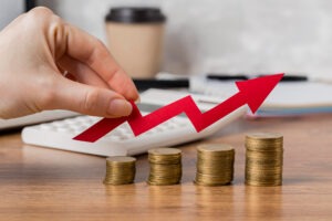 Hand holding growth arrow with coins
